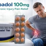 Aspadol 100mg tablets for chronic injury pain relief with man holding lower back pain indoors